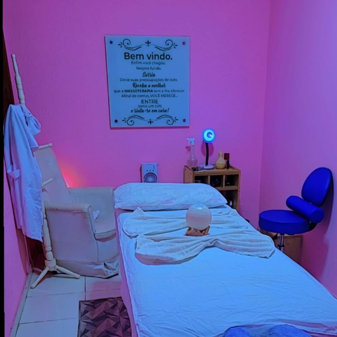 Maca arrumada com toalhas em formato de laço e luminária de sal no centro; placa de boas-vindas